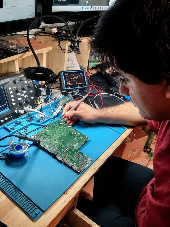 Técnico de SuperTECH diagnosticando una placa en el banco de trabajo